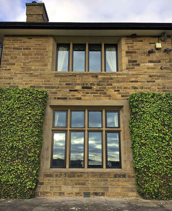 Our slim matt black stepped profile works in harmony with the decorative stone reveals, mullions and transoms on this manor house near Harrogate